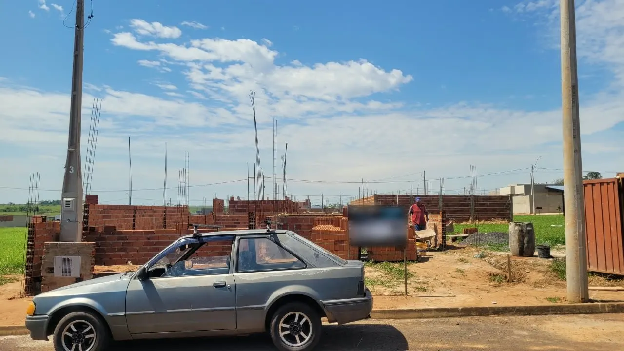 Obra em andamento: paredes de tijolo subindo, ferragens dos pilares à mostra e a placa da Quarto Plano na frente do terreno.